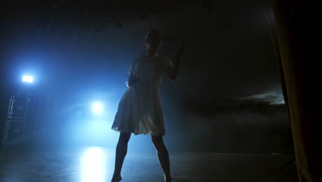 Una-Escena-Dramática-De-Ballet-Moderno-Una-Bailarina-Solitaria-Con-Un-Vestido-Blanco-Realiza-Pasos-De-Baile-Utilizando-Coreografía-Moderna.